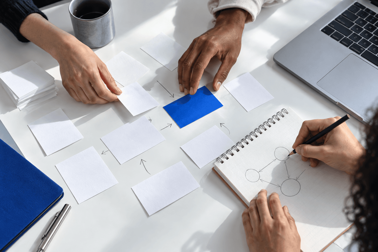 Builders arranging paper notes and sketching connected ideas together